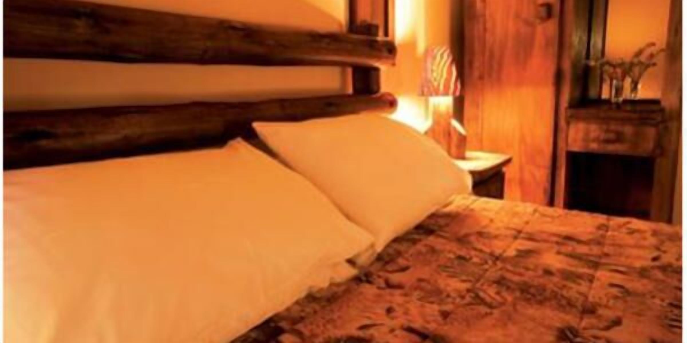 Un letto con una testiera in legno e una coperta a motivi.