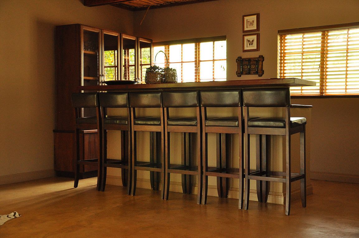 Un espace bar avec des chaises en bois et un comptoir.