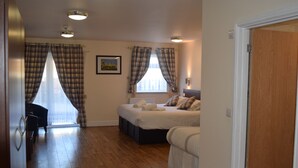 A bedroom with a double bed, a chair, a window with curtains, and a radiator. - Star Anglia Hotel (Colchester)