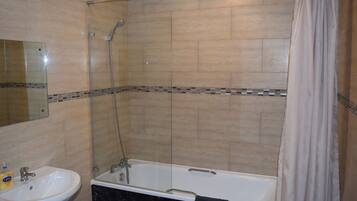 Un baño con bañera, ducha y lavamanos.