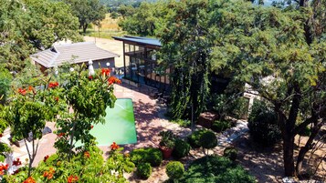 Una piscina al aire libre, sombrillas, sillones reclinables de piscina