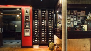 A wine cellar with numerous wine racks and framed pictures on the walls. - Villa Eva (Gdansk)