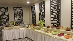 A buffet table with various food items and a decorative wall panel in the background. - Ayder Hanedan Hotel (Ardesen)