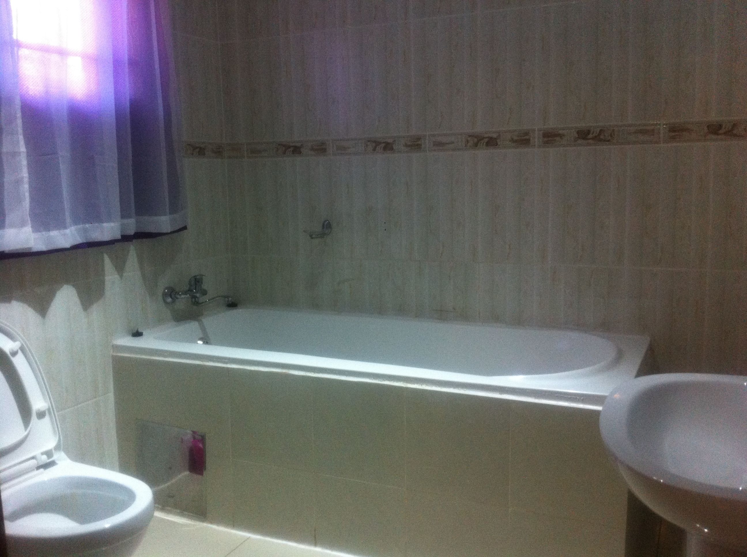 A bathroom with a toilet, bathtub, and sink.