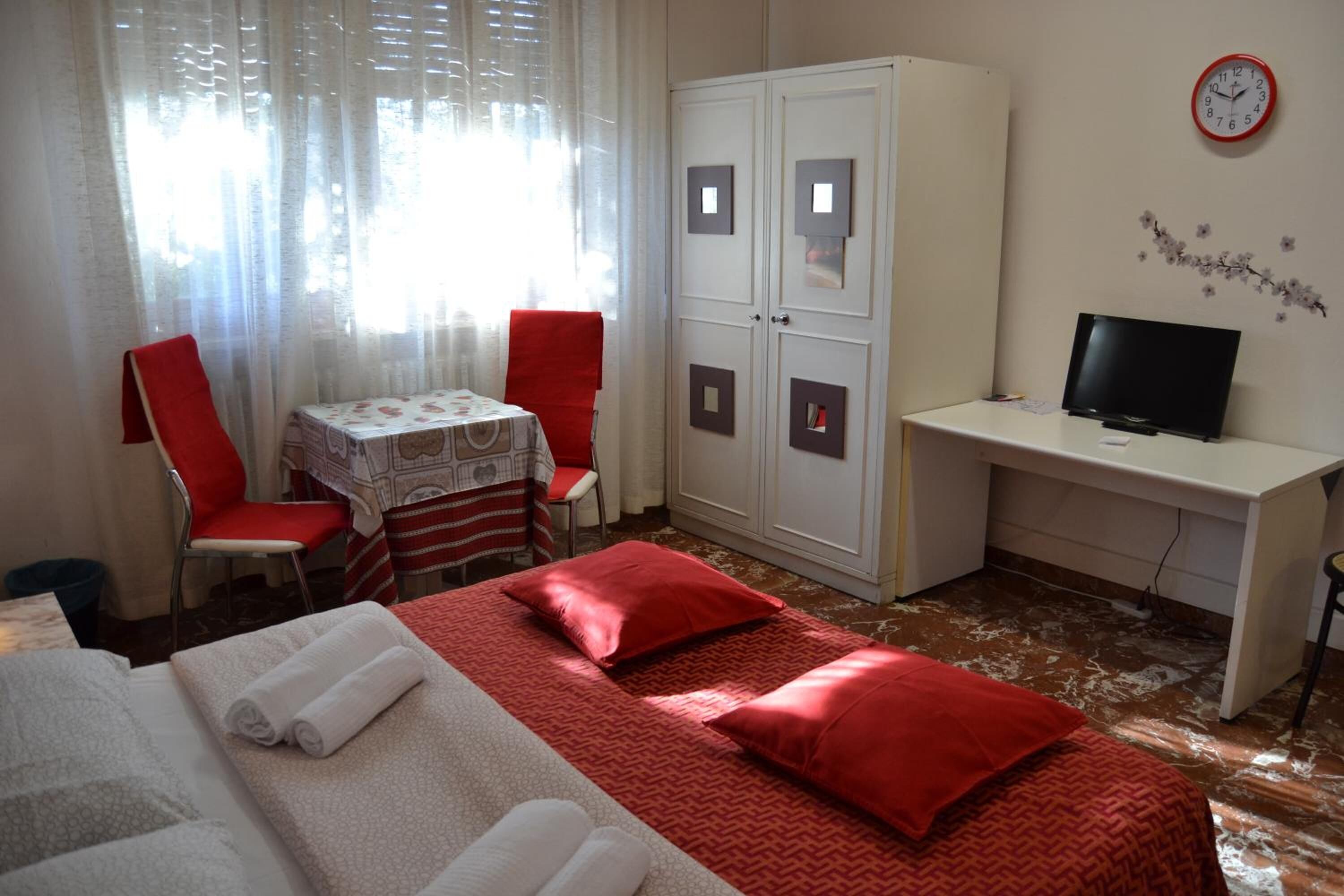 Une chambre d’hôtel équipée d’un lit, d’un bureau, d’une télévision et d’une armoire.