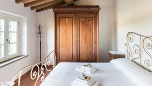 A bedroom with a bed, wooden wardrobe, and a window. - Luxury Tuscany Villa with Private Pool, 13 Sleeps. Lucca 10 km. (San Ginese Di Compito Lucca)