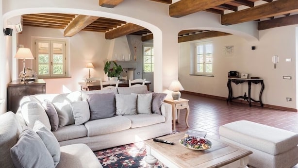 A spacious living room with a sofa, a coffee table, and a dining area with a table and chairs. - Luxury Tuscany Villa with Private Pool, 13 Sleeps. Lucca 10 km. (San Ginese Di Compito Lucca)