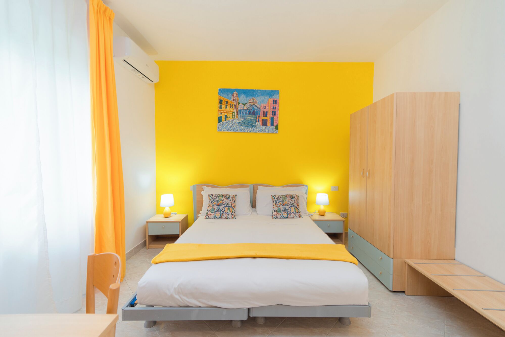Un dormitorio con una cama, dos mesitas de noche, un armario y un cuadro en la pared.