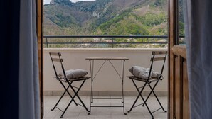 A balcony with two foldable chairs and a small table, overlooking a mountainous landscape. - Tra i Monti (Tramonti)