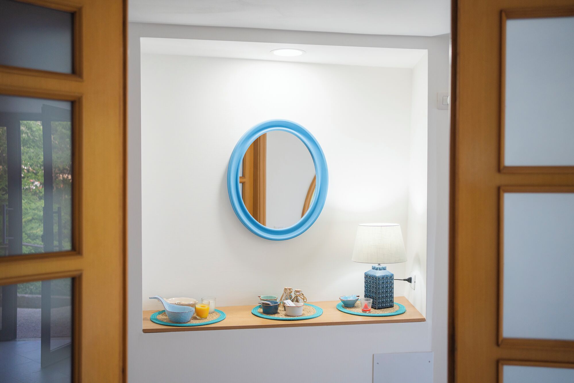 A bathroom with a mirror, a sink, and a towel rack.
