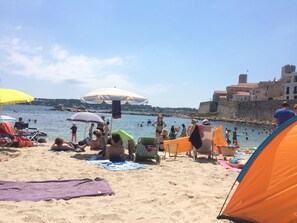 A beach with people sunbathing, swimming, and walking along the shore. - 20m2 fully renovated Studio with Private Balcony, rates are All Inclusive. (Antibes)