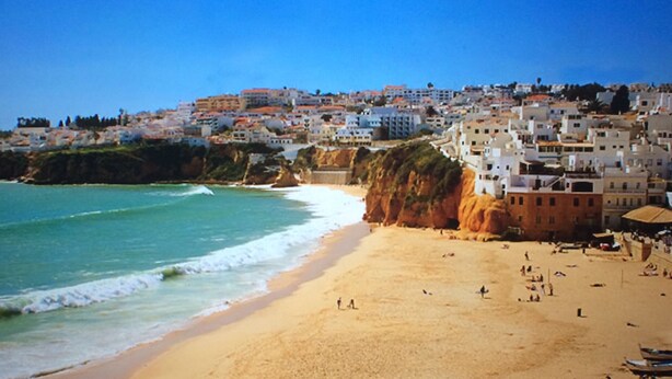 A coastal town with a sandy beach and buildings along the cliffside. - Luxury apartment in a private and relaxing complex (Albufeira)