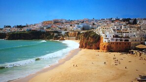 Une ville côtière dotée d’une plage de sable et de bâtiments construits le long de la falaise.