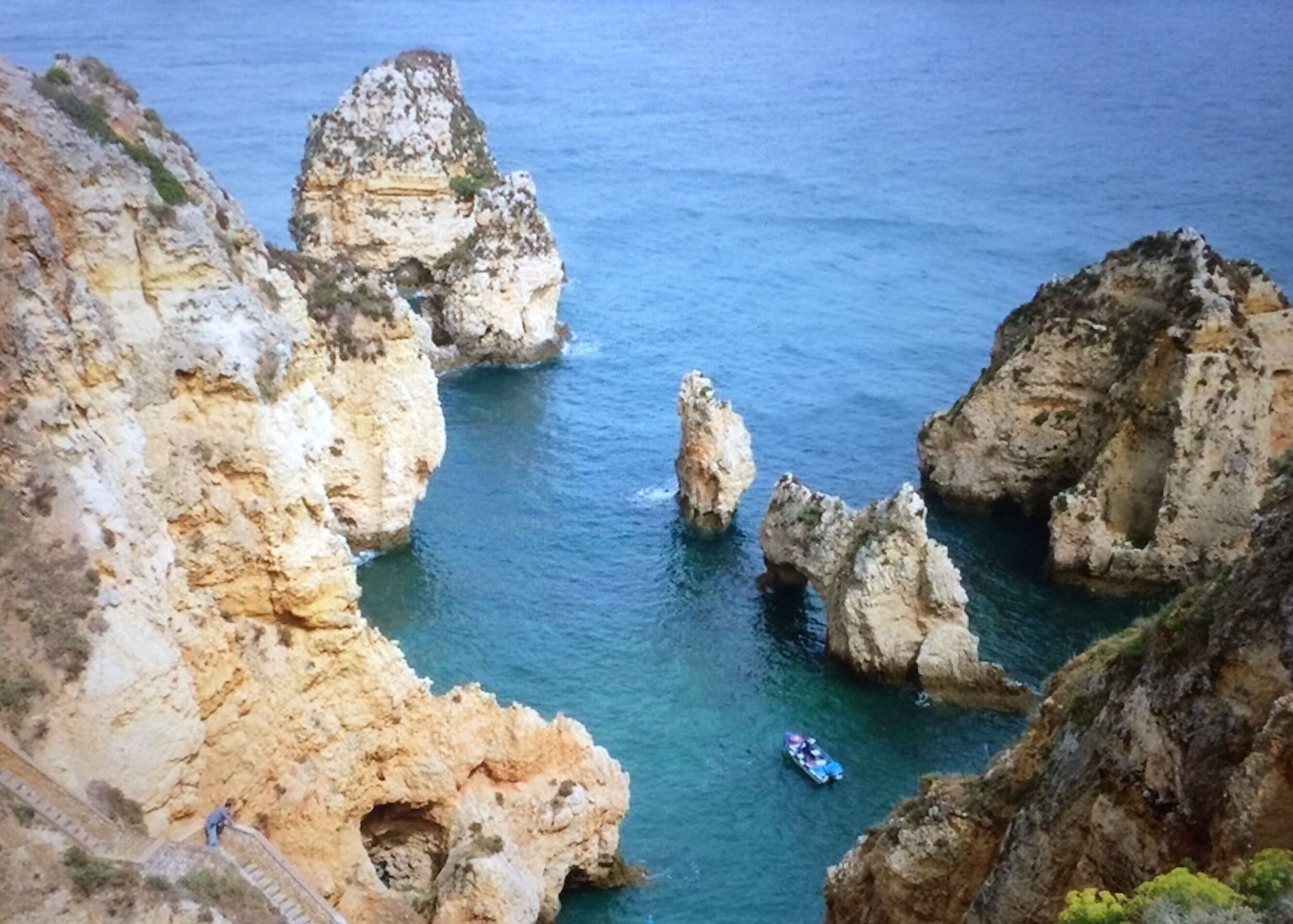 Un paysage côtier caractérisé par des formations rocheuses et une eau d’un bleu limpide.