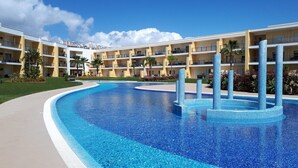 A hotel with a large pool, multiple balconies, and a clear blue sky. - Luxury apartment in a private and relaxing complex (Albufeira)