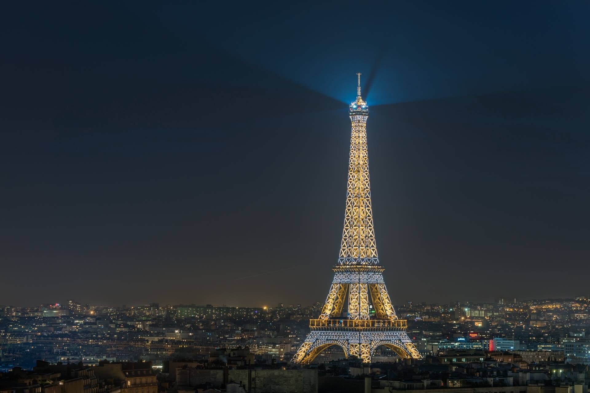 Der Eiffelturm bei Nacht, beleuchtet mit Lichtern.