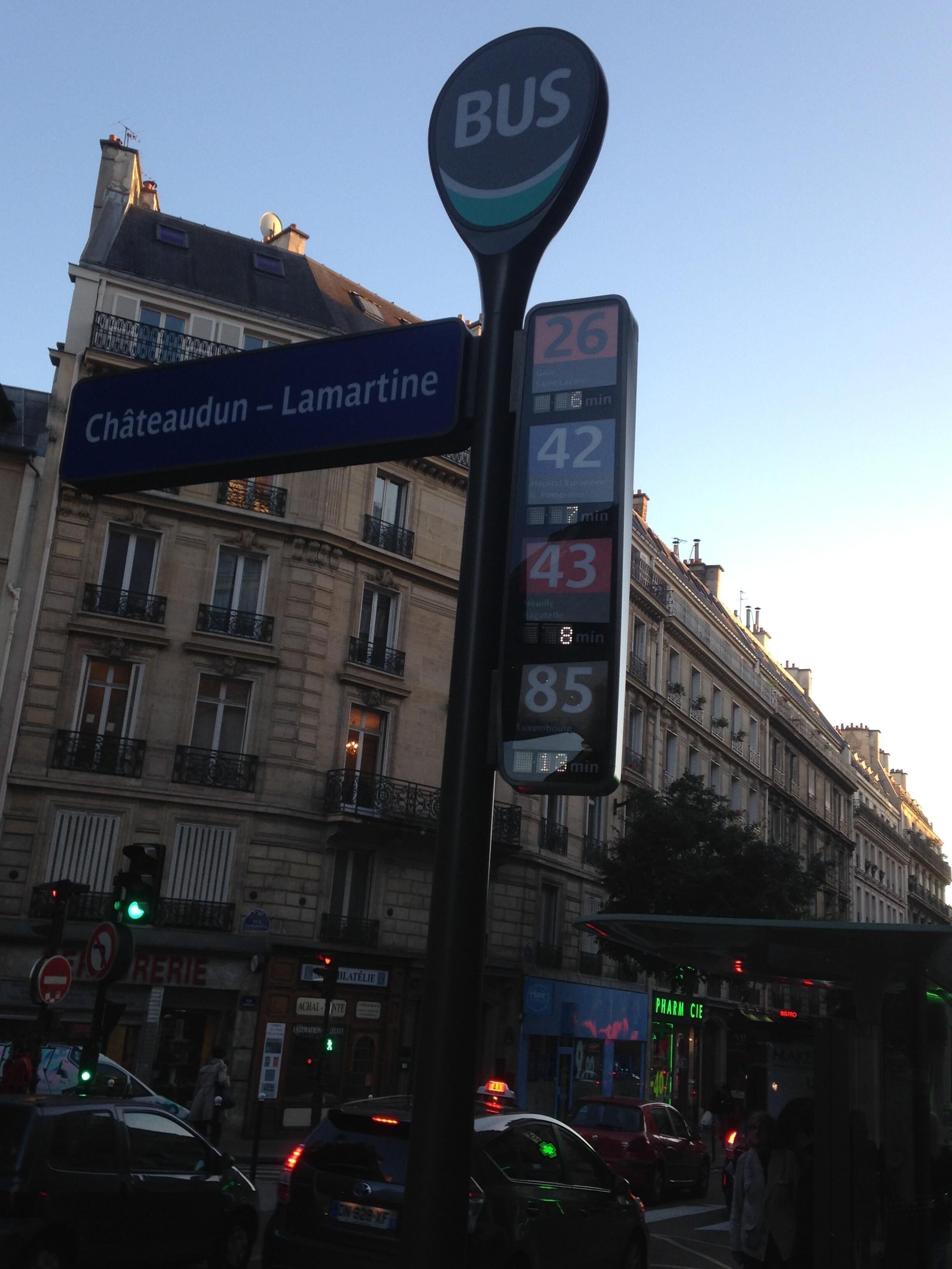 Señal de parada de autobús con números de ruta y señal de calle para 'Châteaudun - Lamartine'.