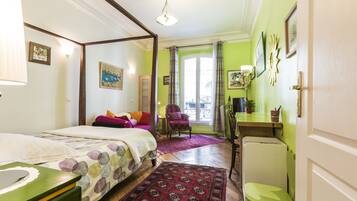 Un dormitorio con cama con dosel, un escritorio y una silla.