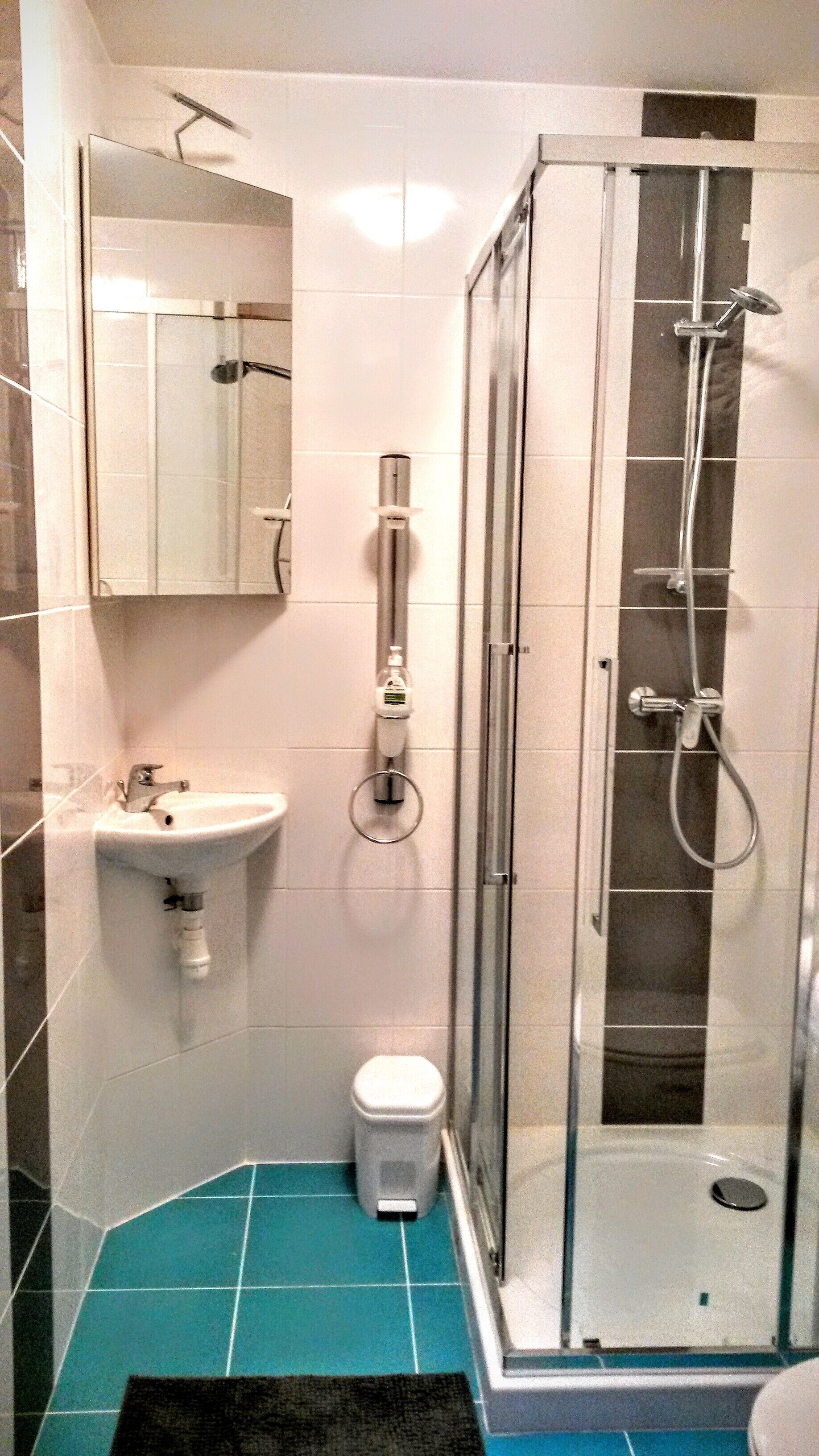A bathroom with a shower, sink, and toilet.