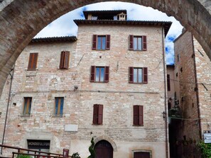 A stone building with multiple windows and a sign that reads "WONDERFUL STORE". - PATIO HOUSE balcony shabby chic home in Spello (Spello)