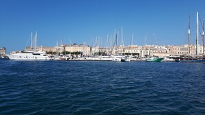 A marina with multiple sailboats docked, surrounded by buildings with Mediterranean architecture. - Apartment in Ortigia furnished and equipped with all comforts (Siracusa)