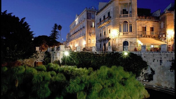 A historic building with classical architecture, featuring multiple balconies and a stone facade. - Apartment in Ortigia furnished and equipped with all comforts (Siracusa)
