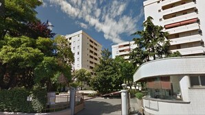 A multi-story residential building with balconies, surrounded by trees and a gated entrance. - Exclusive apartment of 120 sqm, 4-6 sleeps, private parking (Milano)