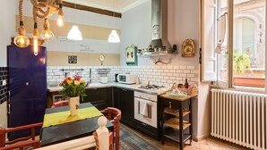 Una cocina con un refrigerador azul, estufa, microondas y luces colgantes.