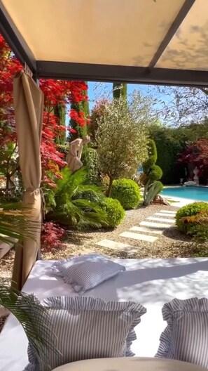 A covered outdoor seating area with a pool in the background. - VILLA FLORENCE LUXURY RELAIS 24H SERVICE PRIVATE CHEF and Breakfast Basket (Camaiore)