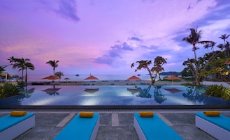 Una piscina al aire libre, sombrillas, sillones reclinables de piscina