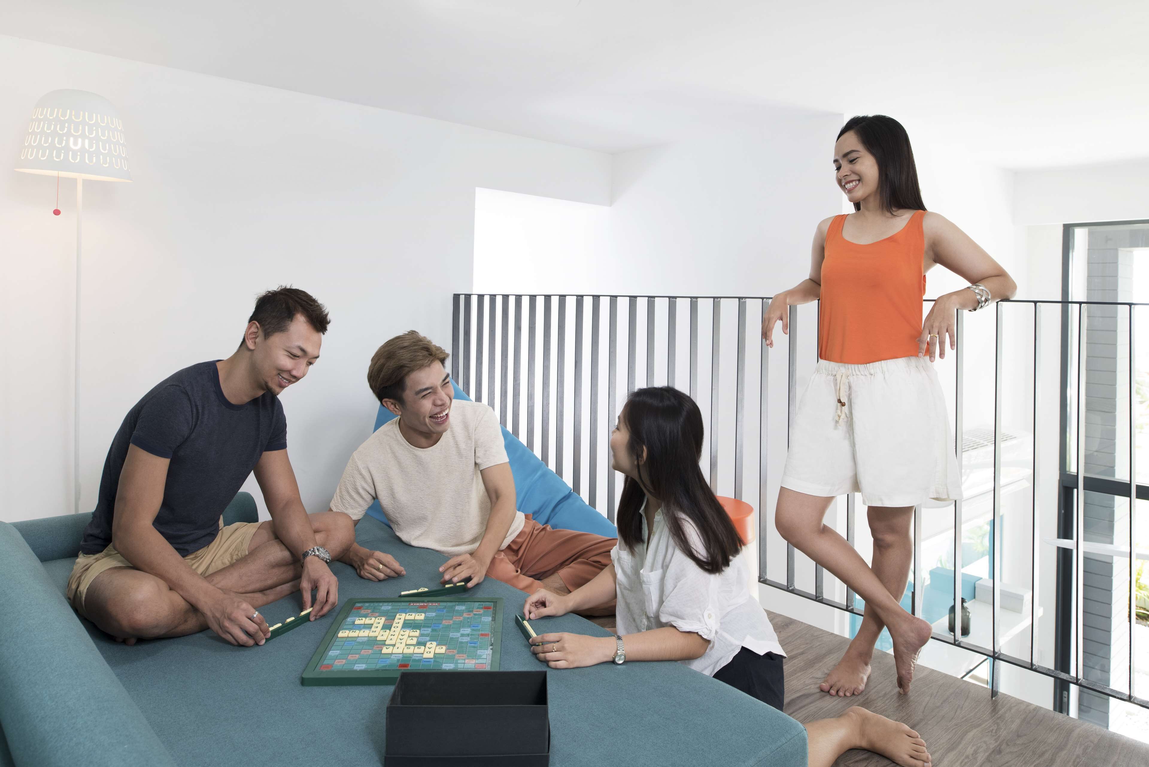 A group of people playing a board game on a sofa in a modern living room with a minimalist design.