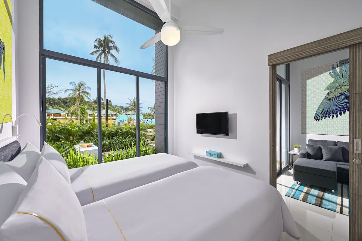 A hotel room with two beds, a TV, and a balcony with a view of palm trees and a pool.