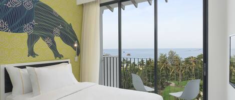 A hotel room with a bed, a balcony with a view of the sea, and a chair.