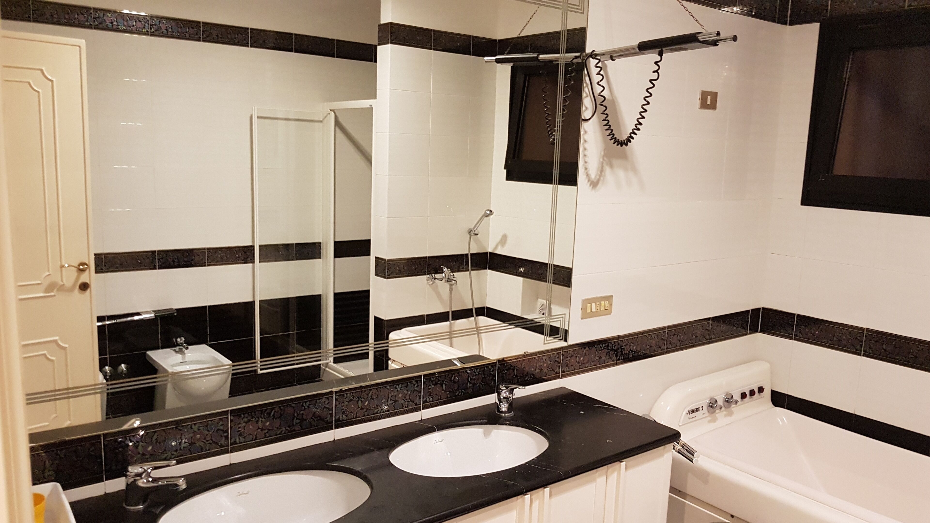Ein Badezimmer mit zwei Waschbecken, einer Badewanne und einer Dusche.