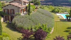 A stone house with a swimming pool, surrounded by lush greenery and rolling hills. - Casale Delle Lavande 10, Emma Villas (Todi)