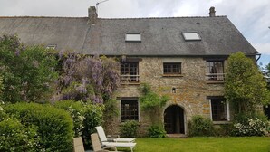 A stone building with a sloped roof, a small garden with a lawn, and a row of lounge chairs. - Beautifully Restored Detached Stone House (Jugon-Les-Lacs - Commune Nouvelle)