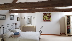 A bedroom with a bed, a dresser, a mirror, and a wardrobe. - Beautifully Restored Detached Stone House (Jugon-Les-Lacs - Commune Nouvelle)