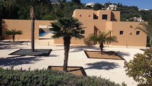 A courtyard with palm trees, a pool, and a building with a modern design. - Amazing Villa - Lagos (Lagos)