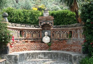 A brick structure with a statue in the center, surrounded by greenery. - Historical country house near Taormina & the sea. Stunning view of Mt Etna (Taormina)