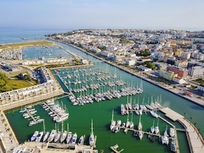 An aerial view of a marina with numerous boats docked, surrounded by urban buildings and a clear sky. - Magnificent apartment very close to Lagos`s Marina (Lagos)