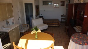 Un espacio habitable compacto con cocina, comedor y habitación.
