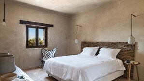 A bedroom with a large bed, a window, a bedside table, and a hanging light fixture. - The Old Beach House - A house by the sea to reconnect with yourself (Keramoti western crete)