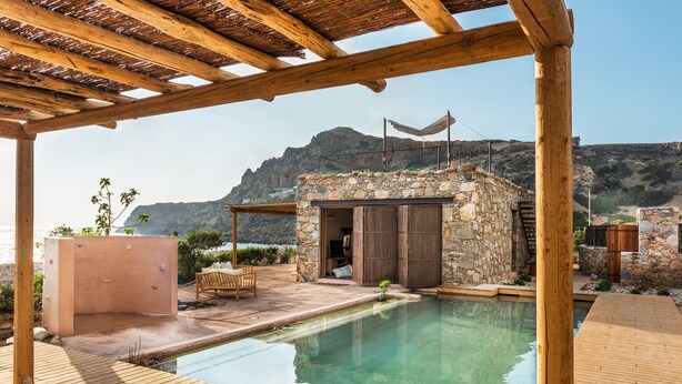A wooden deck with a pool, stone walls, and a view of mountains. - The Old Beach House - A house by the sea to reconnect with yourself (Keramoti western crete)