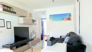 A modern living room with a flat-screen TV, a sofa, a coffee table, and a bookshelf. - CasaYaiza, completely renovated luxury villa (Yaiza)