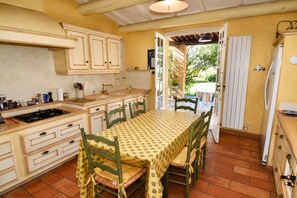 A kitchen with a dining table, chairs, and a view to the outside.
