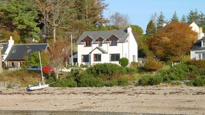 Ein Haus am See mit einem Boot am Ufer.