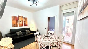 A compact living space with a sofa, a dining table with chairs, a ceiling light fixture, and artwork on the walls. - Parking available. Pets accepted. Subway nearby. Near the Sagrada Familia (Barcelona)