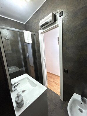 Een douche, een haardroger, een bidet, handdoeken