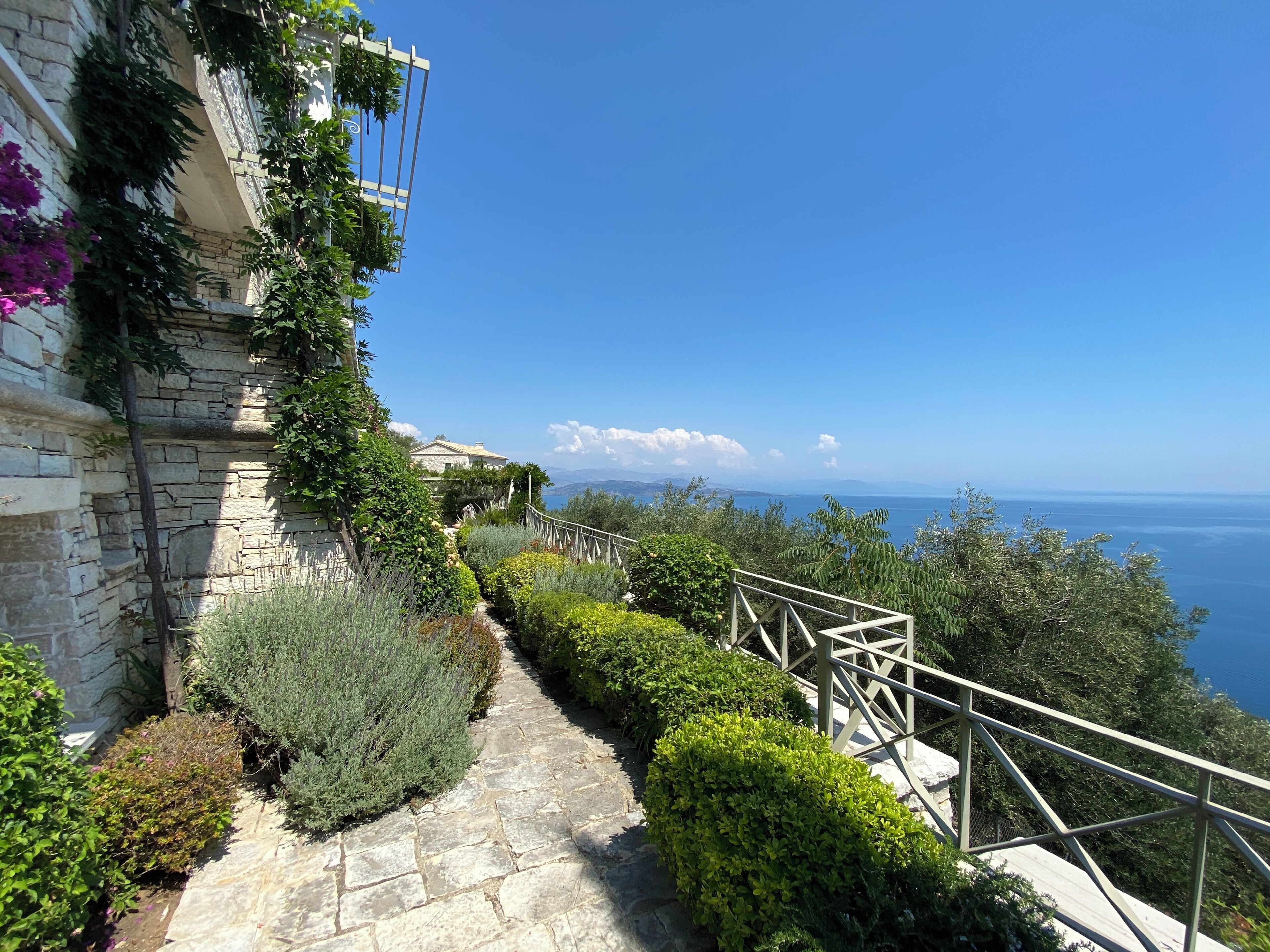 Un chemin de pierre menant à un balcon d’où l’on a vue sur la mer.