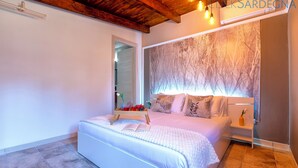 Un dormitorio moderno con una cama grande, mesitas de noche, una lámpara de pared y vistas al exterior.